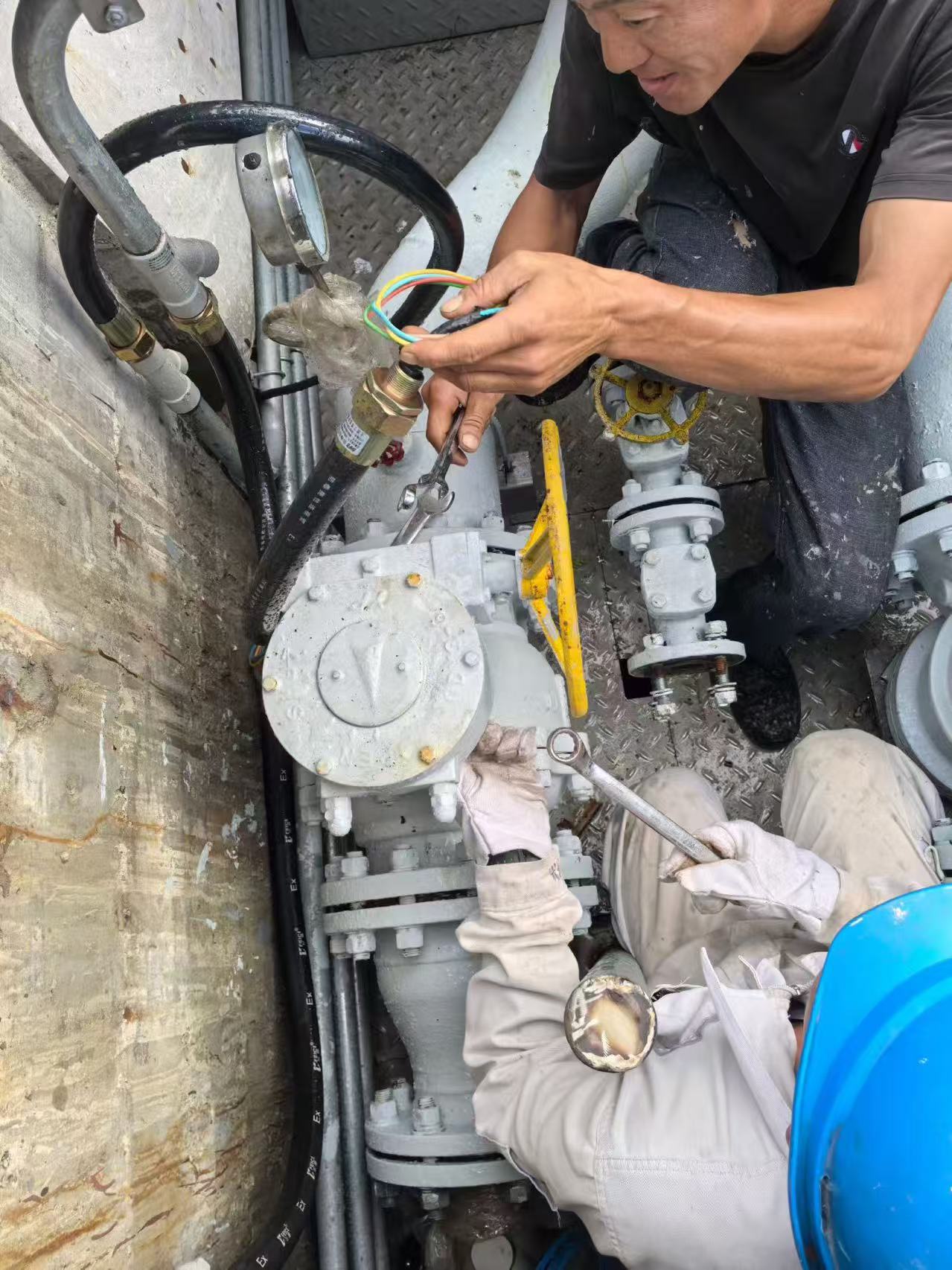 Before retrofit: workers dismantling a DN80 PN16 manual flanged ball valve to install an electric actuator